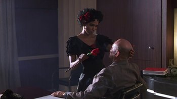 Movie still from “Introducing Dorothy Dandridge” (1999), directed by Martha Coolidge – A woman holding a red rose near a man in a wheelchair; Medium shot, Over the shoulder angle