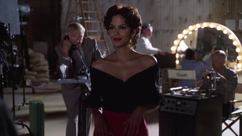 Movie still from “Introducing Dorothy Dandridge” (1999), directed by Martha Coolidge – A woman in a black and red dress standing next to a man; Medium shot, Over the shoulder angle