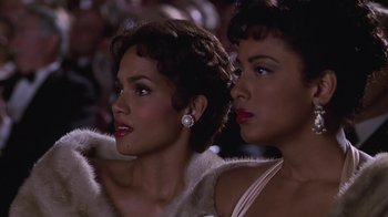 Movie still from “Introducing Dorothy Dandridge” (1999), directed by Martha Coolidge – Two beautiful women sitting next to each other in a crowd; Close Up shot, Over the shoulder angle