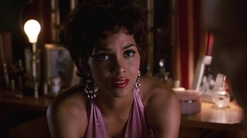 Movie still from “Introducing Dorothy Dandridge” (1999), directed by Martha Coolidge – A woman in a pink dress and silver earrings; Close Up shot, Over the shoulder angle