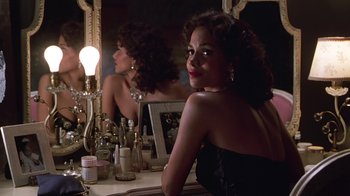 Movie still from “Introducing Dorothy Dandridge” (1999), directed by Martha Coolidge – A woman sitting in front of a mirror in front of a table; Close Up shot, Over the shoulder angle