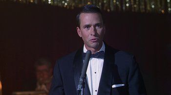 Movie still from “Introducing Dorothy Dandridge” (1999), directed by Martha Coolidge – A man in a tuxedo standing in front of a microphone; Close Up shot, Low angle