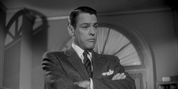 Movie still from “Invasion of the Body Snatchers” (1956), directed by Don Siegel – A man in a suit and tie with his arms crossed; Close Up shot, Low angle