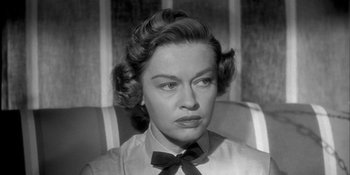 Movie still from “Invasion of the Body Snatchers” (1956), directed by Don Siegel – An old photo of a woman with a black bow tie; Close Up shot, High angle