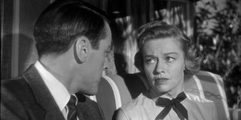 Movie still from “Invasion of the Body Snatchers” (1956), directed by Don Siegel – An old photo of a man and a woman talking to each other; Close Up shot, Over the shoulder angle