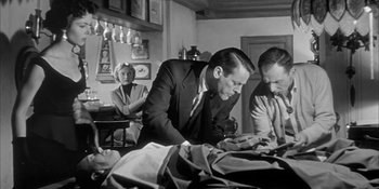 Movie still from “Invasion of the Body Snatchers” (1956), directed by Don Siegel – A black and white photo of a man in a suit and tie; Medium shot, Low angle