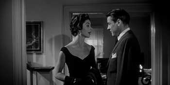 Movie still from “Invasion of the Body Snatchers” (1956), directed by Don Siegel – A man and a woman standing next to each other in a room; Medium shot, Low angle
