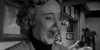 Movie still from “Invasion of the Body Snatchers” (1956), directed by Don Siegel – An old photo of a woman making a funny face; Close Up shot, Low angle