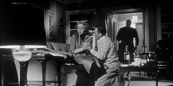 Movie still from “Invasion of the Body Snatchers” (1956), directed by Don Siegel – A man and a woman sitting in a living room; Medium shot, Low angle
