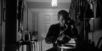 Movie still from “Invasion of the Body Snatchers” (1956), directed by Don Siegel – A black and white photo of a man looking at a camera; Medium shot, Low angle