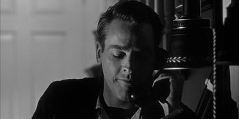 Movie still from “Invasion of the Body Snatchers” (1956), directed by Don Siegel – A black and white photo of a man talking on a phone; Close Up shot, Low angle