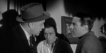 Movie still from “Invasion of the Body Snatchers” (1956), directed by Don Siegel – A black - and - white photo of three men talking; Medium shot, Over the shoulder angle