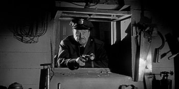 Movie still from “Invasion of the Body Snatchers” (1956), directed by Don Siegel – An old man in a uniform holding a pair of scissors; Medium shot, Low angle