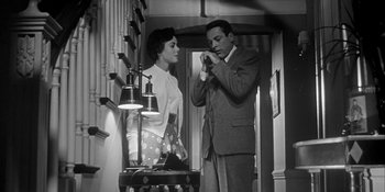 Movie still from “Invasion of the Body Snatchers” (1956), directed by Don Siegel – A man and a woman standing next to each other in a room; Medium shot, Low angle