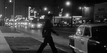 Movie still from “Invasion of the Body Snatchers” (1956), directed by Don Siegel – A man walking across a street at night; Wide shot, Low angle