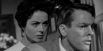 Movie still from “Invasion of the Body Snatchers” (1956), directed by Don Siegel – A woman and a man sitting next to each other in front of each other; Close Up shot, Low angle