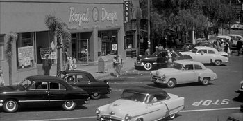 Movie still from “Invasion of the Body Snatchers” (1956), directed by Don Siegel – An old photo of a busy city street with old cars; Extreme Wide shot, High angle