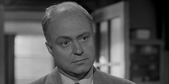 Movie still from “Invasion of the Body Snatchers” (1956), directed by Don Siegel – An older man in a suit and tie looking to his left; Close Up shot, Over the shoulder angle