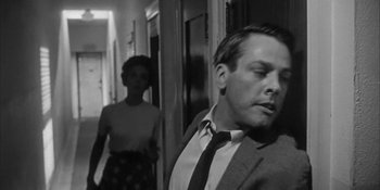 Movie still from “Invasion of the Body Snatchers” (1956), directed by Don Siegel – A man and a woman are standing in a hallway; Close Up shot, Over the shoulder angle