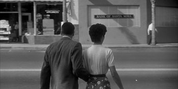 Movie still from “Invasion of the Body Snatchers” (1956), directed by Don Siegel – A man and a woman walking down a street; Medium shot, Low angle