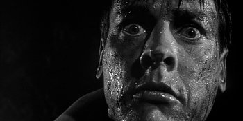 Movie still from “Invasion of the Body Snatchers” (1956), directed by Don Siegel – Black and white photograph of a man's face covered in dirt; Extreme Close Up shot, Low angle