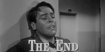 Movie still from “Invasion of the Body Snatchers” (1956), directed by Don Siegel – A black and white photo of a man in a suit and tie; Close Up shot, Low angle