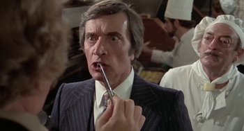 An older man in a suit and tie brushing his teeth
