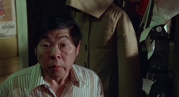 Movie still from “Invasion of the Body Snatchers” (1978), directed by Philip Kaufman – An older asian man in a striped shirt; Medium shot, High angle