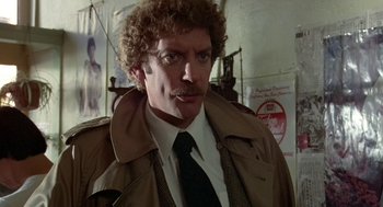 Movie still from “Invasion of the Body Snatchers” (1978), directed by Philip Kaufman – A man in a trench coat and a tie; Close Up shot, Over the shoulder angle