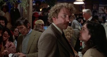 Movie still from “Invasion of the Body Snatchers” (1978), directed by Philip Kaufman – A man in a suit and tie standing next to a crowd; Close Up shot, Over the shoulder angle