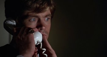 Movie still from “Invasion of the Body Snatchers” (1978), directed by Philip Kaufman – A man holding a remote control in his hand; Close Up shot, High angle