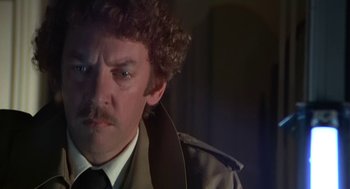 Movie still from “Invasion of the Body Snatchers” (1978), directed by Philip Kaufman – A person wearing a suit and tie; Close Up shot, Over the shoulder angle