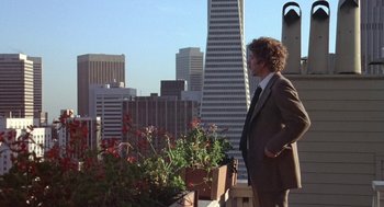 Movie still from “Invasion of the Body Snatchers” (1978), directed by Philip Kaufman – A man in a suit and tie standing next to a flower garden; Wide shot, Low angle