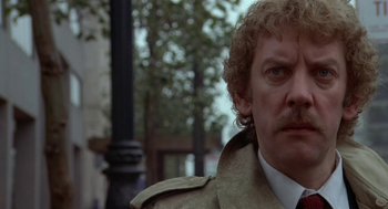 Movie still from “Invasion of the Body Snatchers” (1978), directed by Philip Kaufman – A person wearing a trench coat; Close Up shot, Low angle