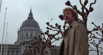 Movie still from “Invasion of the Body Snatchers” (1978), directed by Philip Kaufman – A man standing next to a tree in front of a building; Medium shot, Low angle