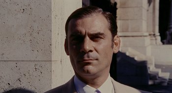 Movie still from “Investigation of a Citizen Above Suspicion” (1970), directed by Elio Petri – A person wearing a suit and tie; Close Up shot, Low angle