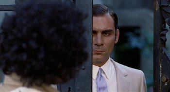 Movie still from “Investigation of a Citizen Above Suspicion” (1970), directed by Elio Petri – A man in a suit and tie looking into a mirror; Close Up shot, Over the shoulder angle