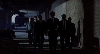 Movie still from “Investigation of a Citizen Above Suspicion” (1970), directed by Elio Petri – A group of men walking down a street at night; Wide shot, Low angle
