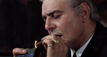 Movie still from “Investigation of a Citizen Above Suspicion” (1970), directed by Elio Petri – A person holding a cigar; Close Up shot, Low angle