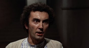 Movie still from “Investigation of a Citizen Above Suspicion” (1970), directed by Elio Petri – A person wearing a shirt and jacket; Close Up shot, Low angle