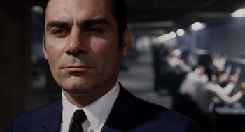Movie still from “Investigation of a Citizen Above Suspicion” (1970), directed by Elio Petri – A person wearing a suit and tie; Close Up shot, Low angle