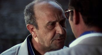 Movie still from “Investigation of a Citizen Above Suspicion” (1970), directed by Elio Petri – An older man is looking at a younger man; Close Up shot, Over the shoulder angle