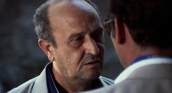 Movie still from “Investigation of a Citizen Above Suspicion” (1970), directed by Elio Petri – An older man is looking at a younger man; Close Up shot, Over the shoulder angle