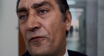 Movie still from “Investigation of a Citizen Above Suspicion” (1970), directed by Elio Petri – A man's face in a business suit; Close Up shot, Low angle