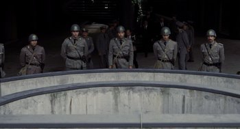 Movie still from “Investigation of a Citizen Above Suspicion” (1970), directed by Elio Petri – A group of men standing next to each other in uniforms; Wide shot, High angle