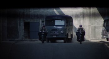 Movie still from “Investigation of a Citizen Above Suspicion” (1970), directed by Elio Petri – Two men on motorcycles driving past a van; Extreme Wide shot, Low angle