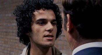 Movie still from “Investigation of a Citizen Above Suspicion” (1970), directed by Elio Petri – A man with curly hair talking to another man; Close Up shot, Over the shoulder angle