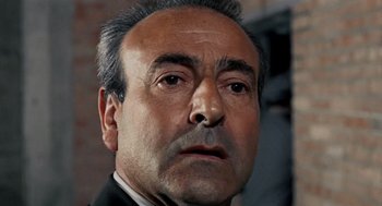 Movie still from “Investigation of a Citizen Above Suspicion” (1970), directed by Elio Petri – An older man with grey hair and a mustache; Close Up shot, Low angle
