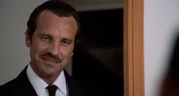 Movie still from “Investigation of a Citizen Above Suspicion” (1970), directed by Elio Petri – A person wearing a suit and tie; Close Up shot, Low angle