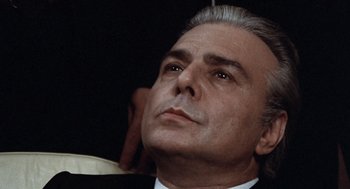 Movie still from “Investigation of a Citizen Above Suspicion” (1970), directed by Elio Petri – An older man in a suit and tie looking up; Close Up shot, Low angle